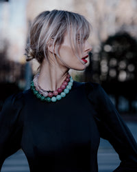 Bowery Downtown necklace including Malachite, Amazonite, Rhodonite and Rose quartz semi precious spheres both layered on models neck