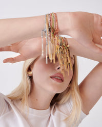 Carolina Bucci Lucky bracelets, Tutto Per Te Earrings in 18k yellow gold worn by model, front view, lifestyle setting