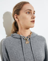 close-up of 18k yellow, white and rose florentine frosted finish gold 1885 grande links short necklace connected to the eye pavé pendant styled on model