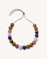 Alphabet city downtown necklace including Unakite, Tiger's eye, Rhodonite, Rose quart  and Lapis lazuli semi precious spheres on white background