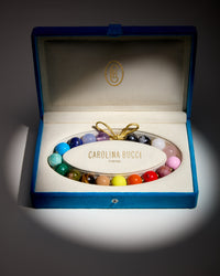 Soho downtown necklace including amethyst, chalcedony, lapis lazuli, amazonite, malachite, unakite, tiger's eye, rhodonite, rose quartz, white agate, snowflake obsidian and hematite semi precious spheres with sky, camel, lemon, terracotta, big apple red and flamingo coloured enamel spheres presented in a blue velvet box