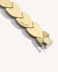Close-up, back view of EveryDay bracelet clasp, brushed 18k yellow gold, engraved logo, on white background