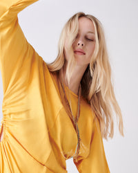 18k yellow gold lucky necklace collection styled on model's neck