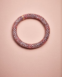 18k pink gold twister luxe pinks bracelet with encased in pavé precious stones including pink, lilac and light blue sapphires set in 18k pink gold on rose background